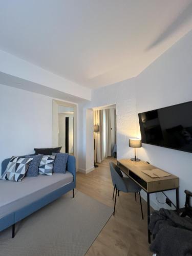a bedroom with a bed and a desk and a television at Hotel San Miguel Menorca in Mahón