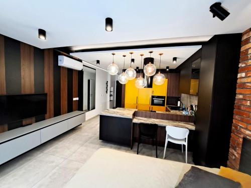 an open kitchen with yellow and black walls at Kima Apartament Bażantów 40 in Katowice