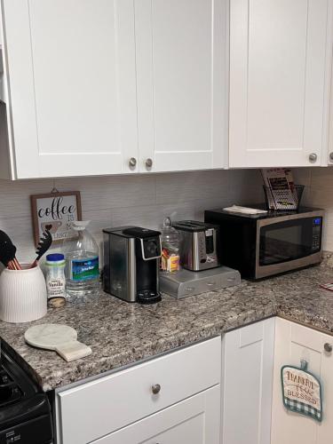 a kitchen with white cabinets and a counter top with appliances at Cozy on the Hill in Wilmington