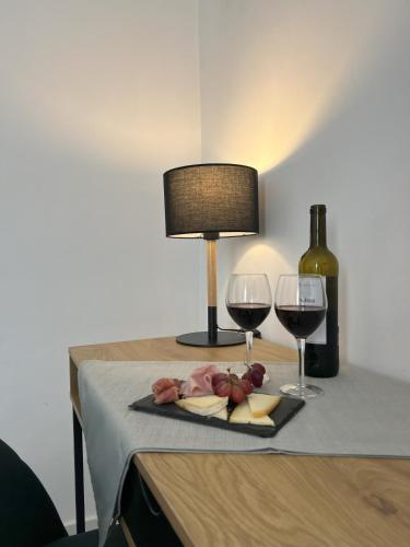 a table with two glasses of wine and a lamp at Hotel San Miguel Menorca in Mahón