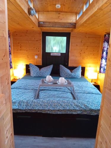 a bedroom with a bed in a wooden cabin at Eisenbahnromantik im Urlaub in Heinsdorfergrund