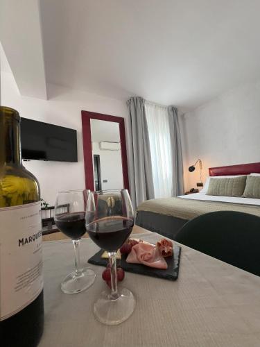 a bottle of wine and two glasses on a table at Hotel San Miguel Menorca in Mahón