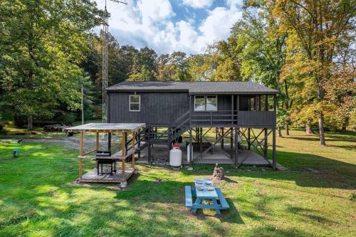 a tiny house with a picnic table and a playground at Riverfront Cabin wFirepit Pool Table Porch WiFi in Hedgesville
