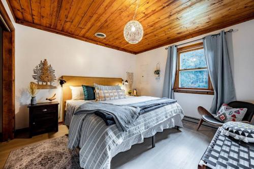 a bedroom with a bed and a wooden ceiling at Riverfront Cabin wFirepit Pool Table Porch WiFi in Hedgesville