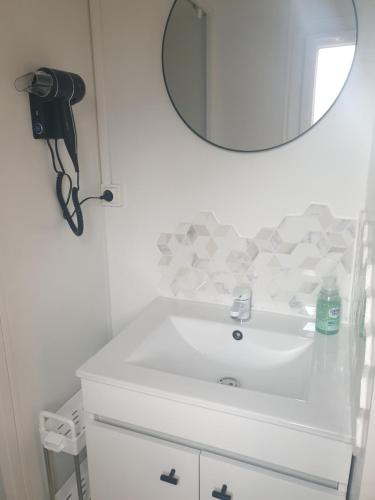 W łazience znajduje się biała umywalka i lustro. w obiekcie Camping Domaine des Iscles w mieście La Roque-dʼAnthéron
