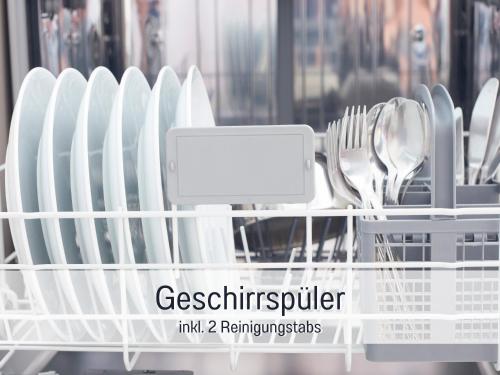 a dish rack filled with plates and utensils at Ferienhaus Küstenzauber Kalifornien - mit Hund - komplett eingezäunter großer Garten - Sauna und Kamin - im Sommer Strandkorb inklusive in Schönberg in Holstein