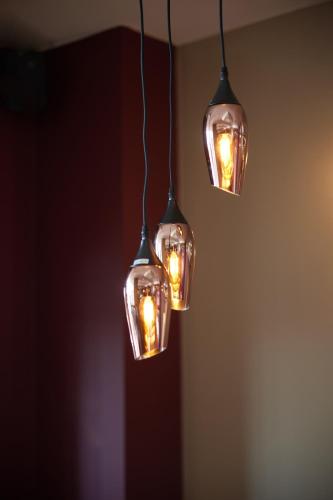 a group of three lights hanging from a ceiling at The Quays by Greene King Inns in Northampton