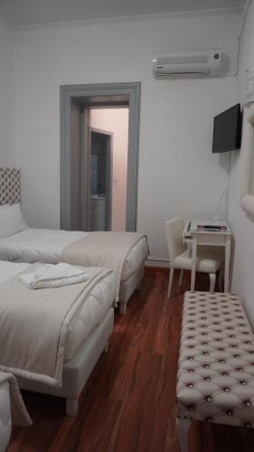 a bedroom with two beds and a table with a chair at Hotel Senhor de Matosinhos in Matosinhos