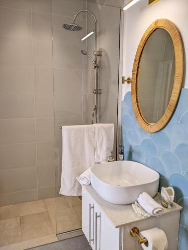 a bathroom with a sink and a mirror at Seaview serenity apartment in Flic-en-Flac