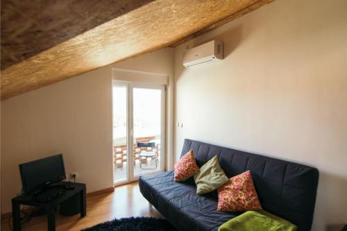 a living room with a blue couch and a television at Akicity Vagos Simple in Ponte de Vagos