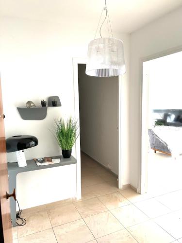 un couloir avec une plante en pot et une lampe pendant dans l'établissement VACANCES RAFFINEES A PIETRANERA, à San-Martino-di-Lota