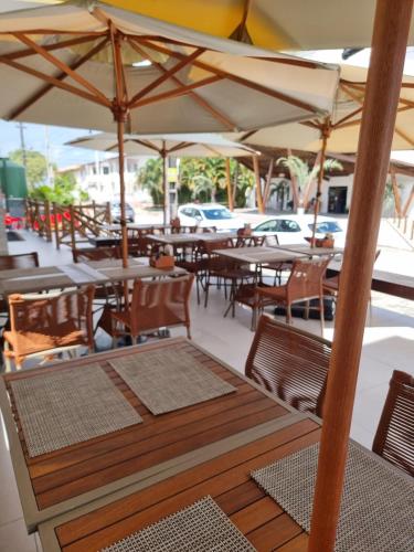 een buitenrestaurant met tafels, stoelen en parasols bij Sunny Hall Acqua com piscina privativa in Porto De Galinhas