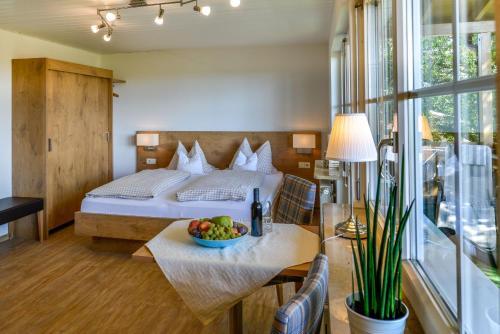 - une chambre avec un lit et une corbeille de fruits sur une table dans l'établissement Ferienhof Walter, à Fribourg-en-Brisgau