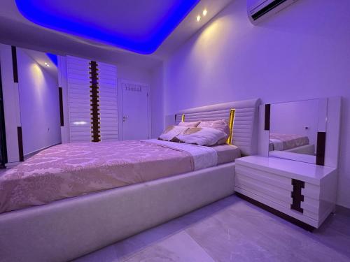Lumos SPA ALL-IN apartment in Luxury resort full facilities في ألانيا: غرفة نوم بسرير كبير وسقف ازرق