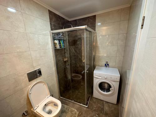uma casa de banho com um chuveiro, um WC e uma máquina de lavar roupa em Lumos SPA ALL-IN apartment in Luxury resort full facilities em Alanya