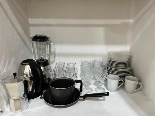 a kitchen counter with glasses and a coffee maker at Apartamento cerca del Aeropuerto in Colonia Mariano Roque Alonso