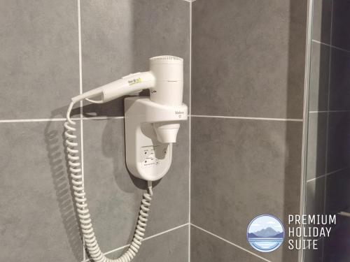 a phone hanging on a wall in a bathroom at Premium Holiday Suite beside Lost World Tambun at Sunway Onsen in Tambun
