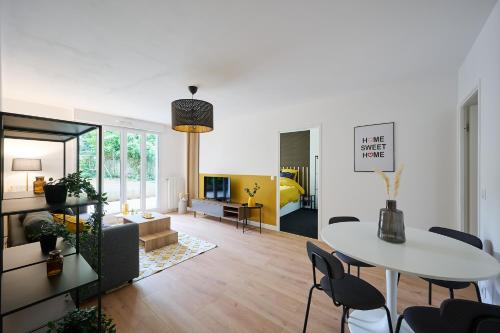 een woonkamer met een witte tafel en stoelen bij YELLOW House - Terrasse - Proche Paris et transports - Tout équipé in Montfermeil