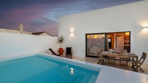 a house with a swimming pool and a dining room at Villas Mont-Blanc in Reguengos de Monsaraz