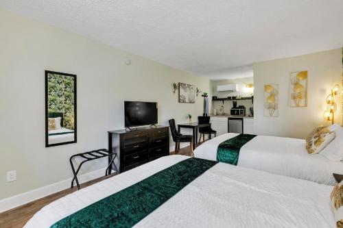 a hotel room with two beds and a flat screen tv at Beachside Boutique Suite 4 in Sneads Ferry