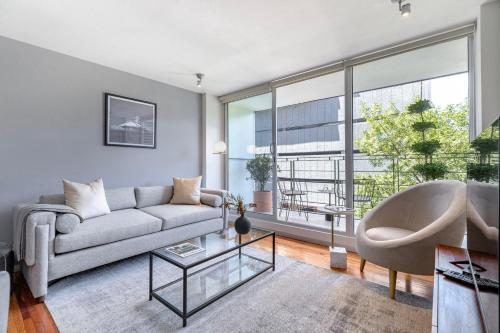 a living room with a couch and a large window at Homero 1433, in Polanco by Blueground in Mexico City