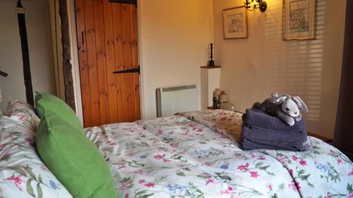un animal de peluche sentado encima de una cama en Finest Retreats - Woodend - The Buttery, en Ulpha