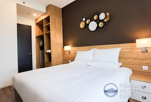 een slaapkamer met een groot bed en 2 klokken aan de muur bij Premium Holiday Suite beside Lost World Tambun in Tambun