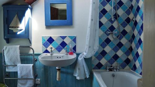 La salle de bains est pourvue d'un lavabo et d'une baignoire. dans l'établissement Finest Retreats - Woodend - The Cottage, à Ulpha