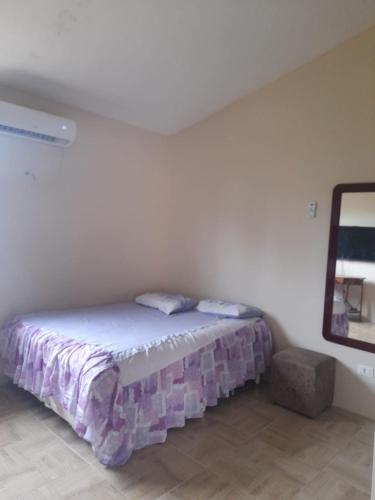 een slaapkamer met een bed in een witte kamer bij Temporada Tamandaré in Tamandaré