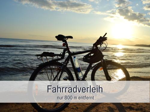 a bike parked on the beach near the ocean at Ferienhaus Küstenzauber Kalifornien - mit Hund - komplett eingezäunter großer Garten - Sauna und Kamin - im Sommer Strandkorb inklusive in Schönberg in Holstein
