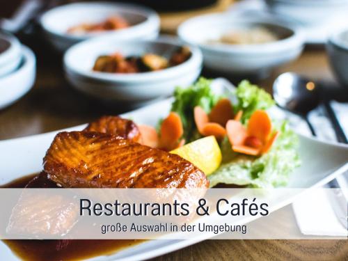 a plate of food with meat and vegetables on a table at Ferienhaus Küstenzauber Kalifornien - mit Hund - komplett eingezäunter großer Garten - Sauna und Kamin - im Sommer Strandkorb inklusive in Schönberg in Holstein