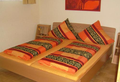 a bed with colorful blankets and pillows on it at Ferienhaus Gut Düneburg in Haren