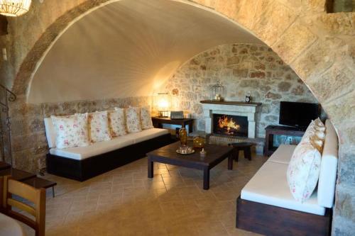 a living room with a couch and a fireplace at Villa Agia Sofia ένα υπέροχο καταφύγιο στο βουνό in Ayía Sofía