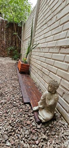 a statue of a little girl sitting on a bench next to a wall at Nuestra Recova en Pilar BsAs in Pilar