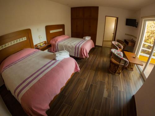 a hotel room with two beds and a table and chairs at La Cañada in Guanajuato