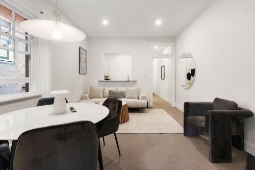 a living room with a couch and a table and chairs at Stunning Terraced Apartment near the Sydney Opera House in Sydney