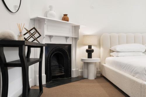 a bedroom with a fireplace next to a bed at Stunning Terraced Flat near the Sydney Opera House in Sydney