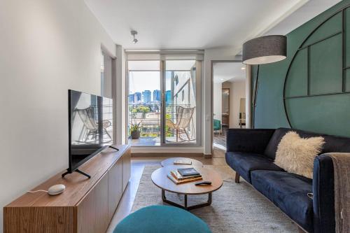 a living room with a couch and a tv at Homero 1433, in Polanco by Blueground in Mexico City