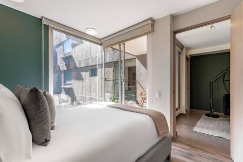 a bedroom with a large bed and a large window at Homero 1433, in Polanco by Blueground in Mexico City