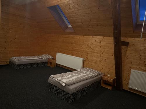 2 letti in una camera con muro di mattoni di Motorest Na Ráně a Rakovník