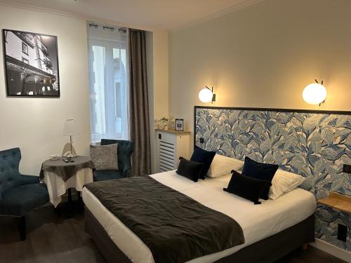 a hotel room with a bed and a chair at Le Grand Hôtel Mont Dore in Le Mont-Dore