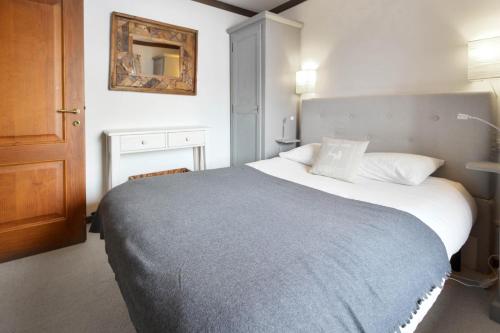 a bedroom with a large bed with a blue blanket at Les Grand Balcon - 2ch - 2 balcons - Randonnée - Escalade - Lac des Chavants in Les Houches