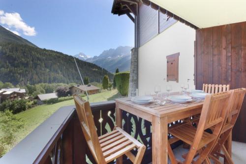 d'une table et de chaises en bois sur un balcon avec vue. dans l'établissement Prarion ski in ski out and swimming pool !, aux Houches