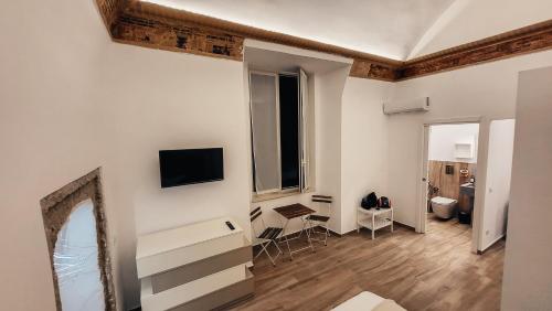 een woonkamer met witte muren en een spiegel bij Duomo Holiday in Napels