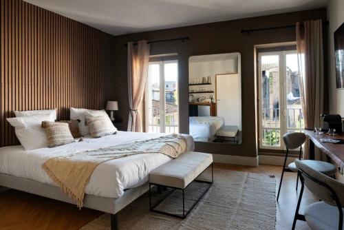 1 dormitorio con 1 cama grande y espejo en L'Évêché/ Clim/ Vue/ Confort, en Carcassonne