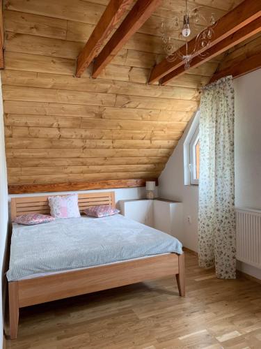 a bed in a room with a wooden ceiling at Chalupa Štúrka in Polomka