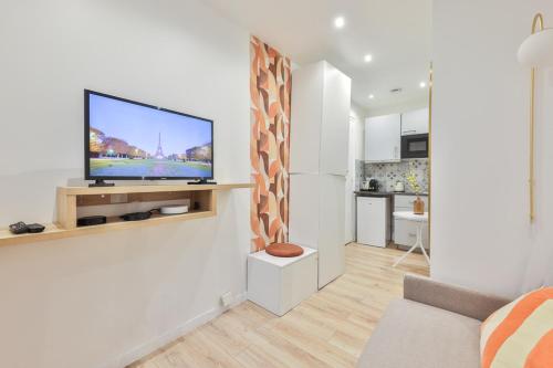 un salon avec une télévision à écran plat sur un mur dans l'établissement Charming studio - 2P - Eiffel Tower, à Paris