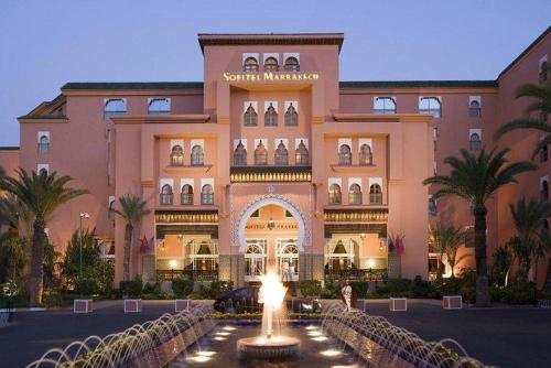 un grand bâtiment avec une fontaine devant lui dans l'établissement Superbe appartement de luxe a l'hivernage marrakech, à Marrakech
