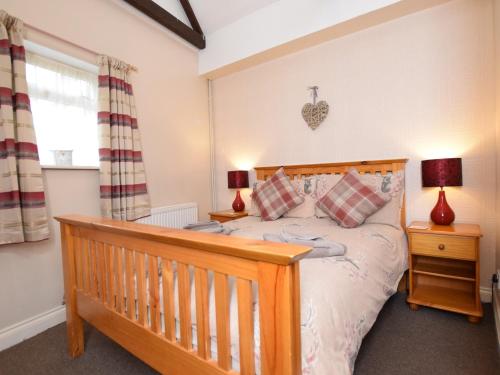 a bedroom with a wooden bed and two lamps at 1 bed in Burnham-on-Sea ALPAD in Highbridge