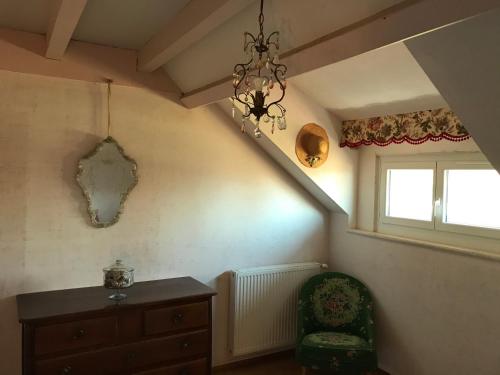 a living room with a chair and a staircase at Grande maison familiale dans le massif des Bauges in Montcel